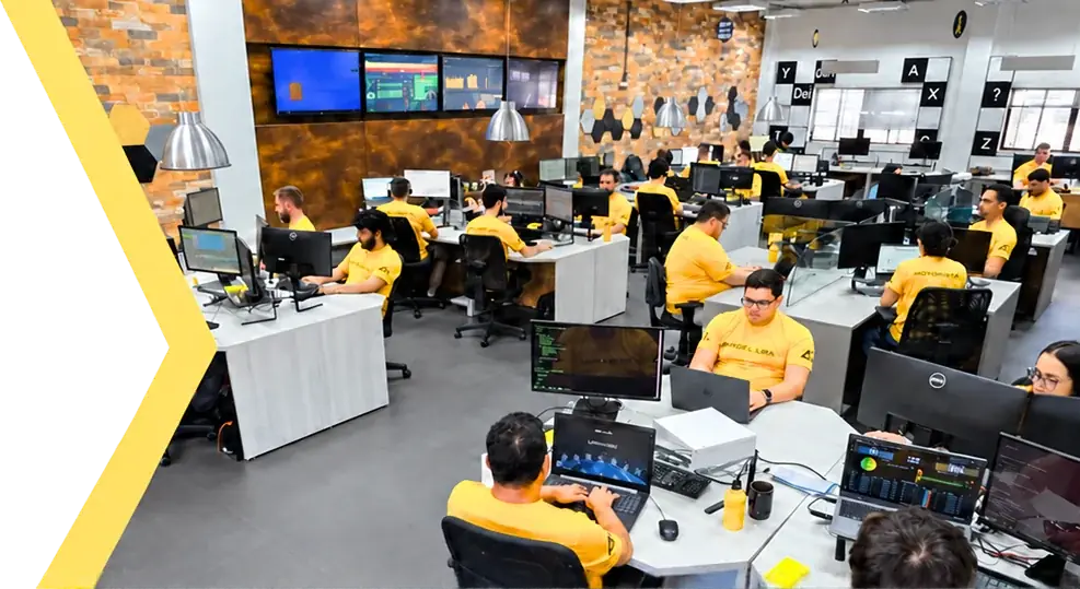 Equipe da Angel Lira, de camiseta amarela, trabalhando na central de operações cheia de monitores